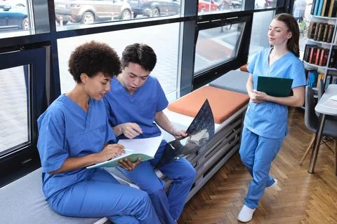 Multicultural group of young intern doctors taking a short coffee break nea.. Stock Photos