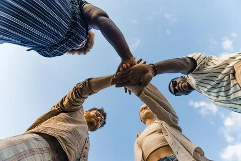 Multicultural group of young people standing in circle and holding their hands Stock Photos