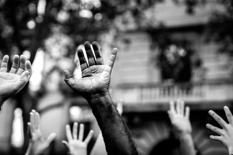 Multicultural hands raised in the air asking for freedom in a demonstration o Stock Photos