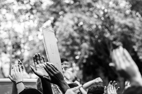 Multicultural hands raised in the air asking for freedom in a demonstration o Stock Photos