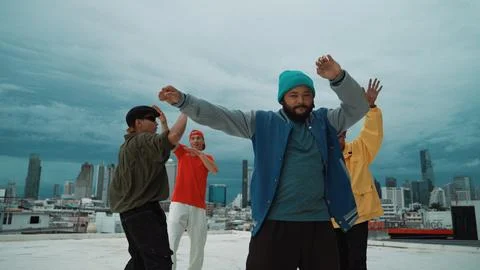 Multicultural hip-hop group dance together at rooftop with city view. Endeavor. Stock Photos