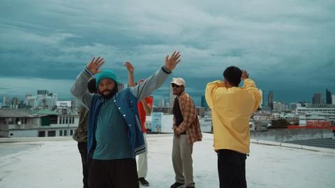 Multicultural hip-hop group dance together at rooftop with city view. Hiphop. Stock Photos