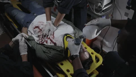 Multicultural paramedics rescuing man in ambulance car Video stock 164918545