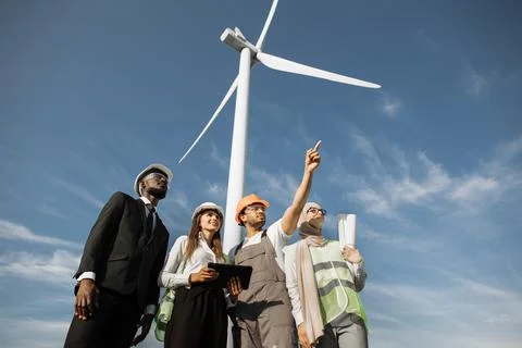 Multicultural partners examining work of wind turbines Stock Photos