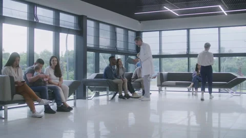 Multicultural people sit on sofas in clinic lobby area Stock Footage 249740610