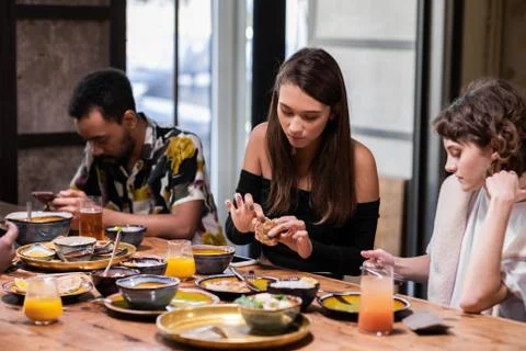 Multicultural students sitting at the table in the common kitche Stock Photos
