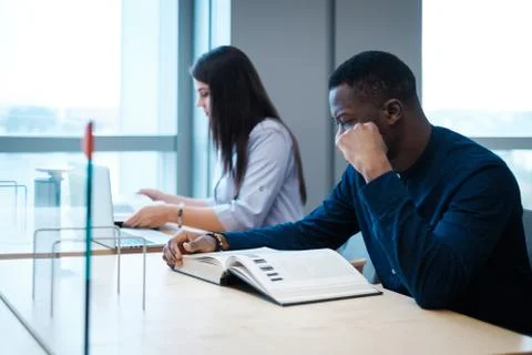 Multicultural students studying in a public library Foto stock