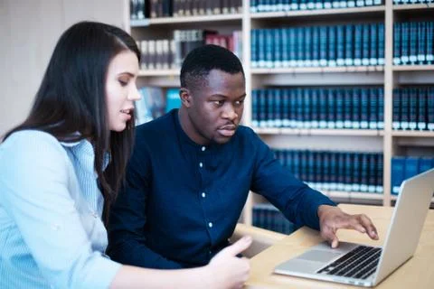 Multicultural students studying in a public library Photos