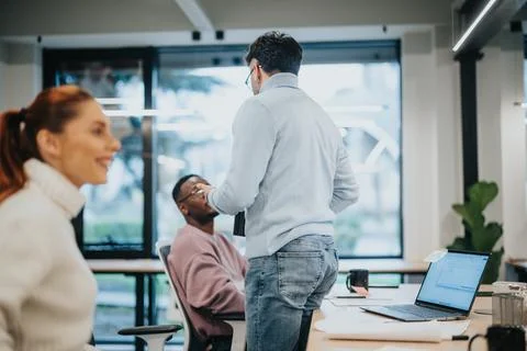 Multicultural team collaborating in a pleasant office atmosphere, discussing Stock Photos