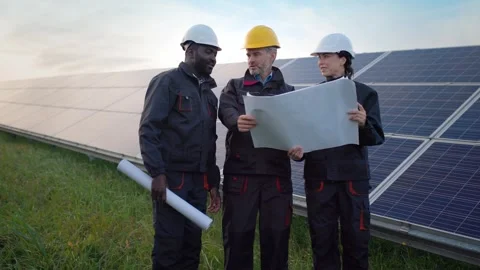Multicultural team of electrical engineers conducted discussion at outdoor solar Stock Footage 242542700