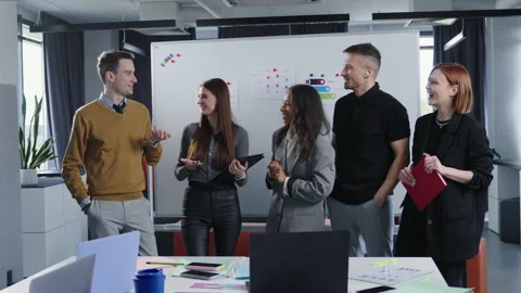 A multicultural team of five people communicates in the office Stock Footage 193974051