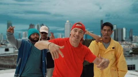 Multicultural teenagers dancing while looking at camera on rooftop. Endeavor. 스톡 사진