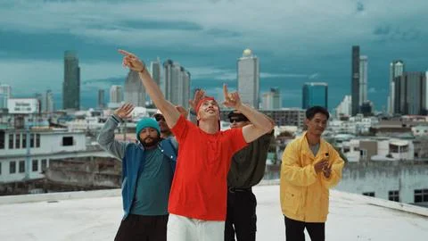 Multicultural teenagers dancing while looking at camera on rooftop. Endeavor. 스톡 사진