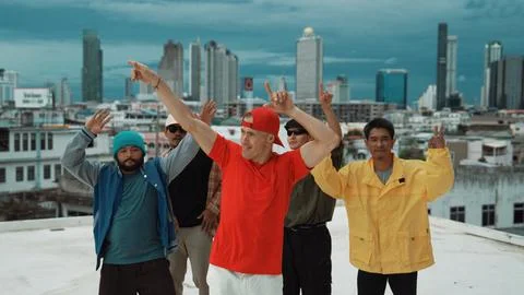 Multicultural teenagers dancing while looking at camera on rooftop. Endeavor. 写真素材
