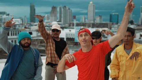 Multicultural teenagers dancing while looking at camera on rooftop. Hiphop. Foto stock