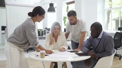 Multicultural young people collaborating on working strategy in office. Stock Footage 233705429