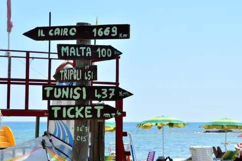 Multidirectional sign with mileage to distant cities and ticket office Fotos Stock