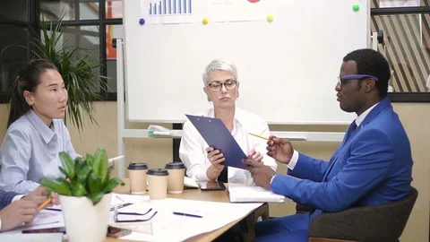 Multiethnic american group talk about new project at desk in modern company. Video stock 94771247