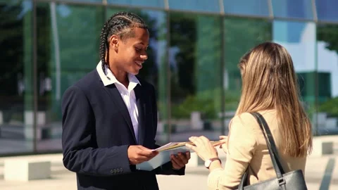 Multiethnic Business partners reviewing documents outside office building Stock Footage 317014348