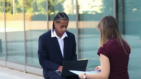 Multiethnic Business partners reviewing documents on a laptop in the financ.. Stock Footage 317014389