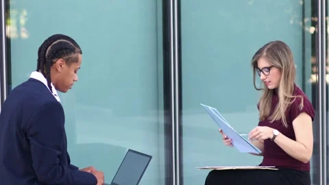 Multiethnic Business partners reviewing documents and working on a laptop Stock Footage 317014409