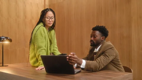 Multiethnic Business Professional Using Laptop and Talking in Office 库存影片 333932859
