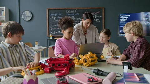 Multiethnic Children with Female Teacher Coding Robot on Laptop Stock Footage 339204265