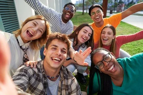 Multiethnic classmate taking a selfie outside of the university, looking at Stock Photos