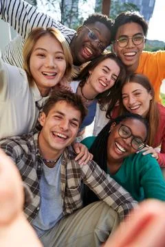Multiethnic classmate taking a selfie outside of the university, looking at Stock Photos