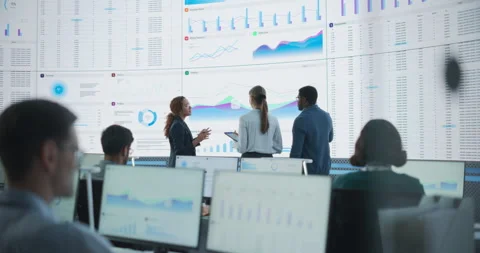 Multiethnic Colleagues Discussing Data On Big Screen Stock Footage 243705003