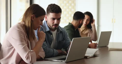 Multiethnic colleagues discussing joint task using laptop met in office Stock Footage 262907167