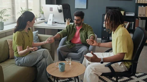 Multiethnic Colleagues Holding Hands for Team Unity in Office Stock Footage 338329908