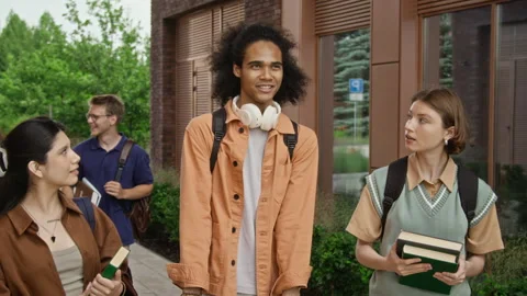 Multiethnic College Students Walking and Talking on Campus Stock Footage 342111155