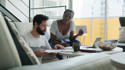 Multiethnic Couple Doing Home Budget And Filing Tax Returns Stock-Footage 130983523