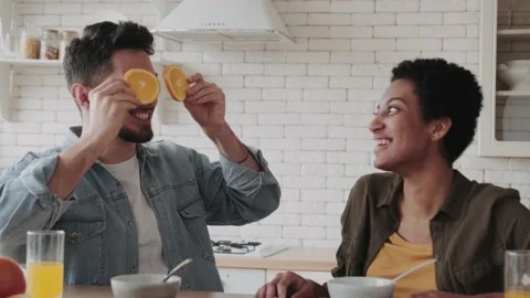 Multiethnic couple having fun and fooling around in the kitchen playing with Stock Footage 236487773