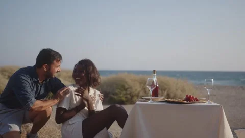 Multiethnic couple having surprise date with celebration picnic on beach Stock Footage 270248435