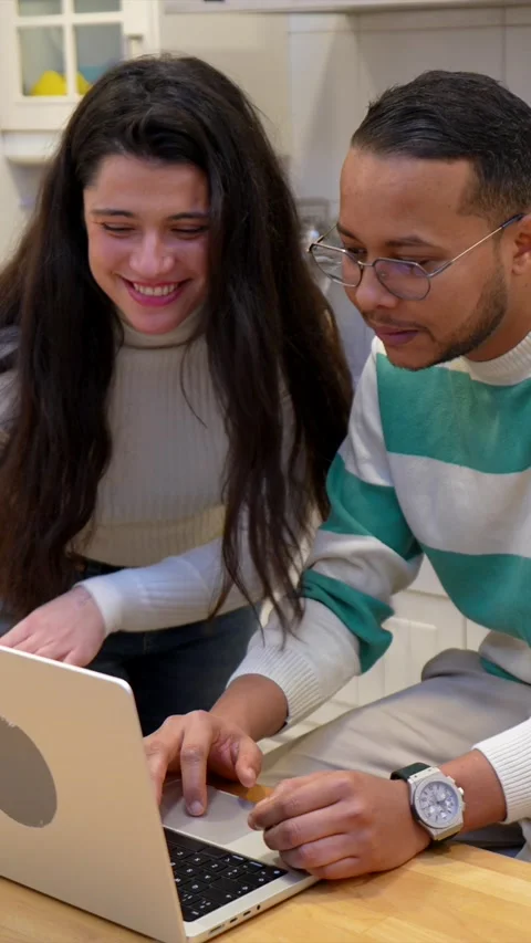 Multiethnic couple making online purchases from home kitchen Stock Footage 334134199
