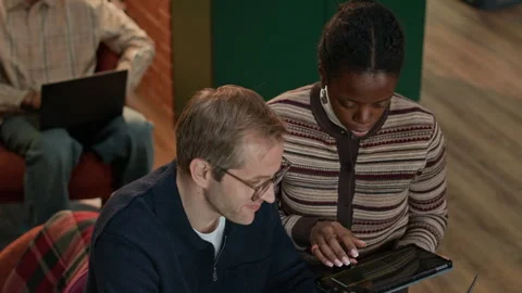 Multiethnic Couple of Programmers Discussing Work in Office Stock Footage 320000077