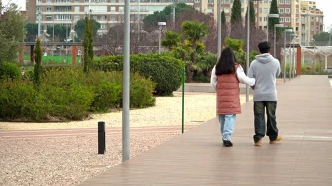 Multiethnic couple on a romantic walk together on the park on Valentine’s Day Stock Footage 328089165
