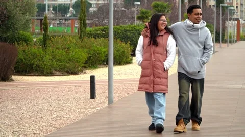Multiethnic couple on a romantic walk together on the park on Valentine’s Day Stock Footage 328089171