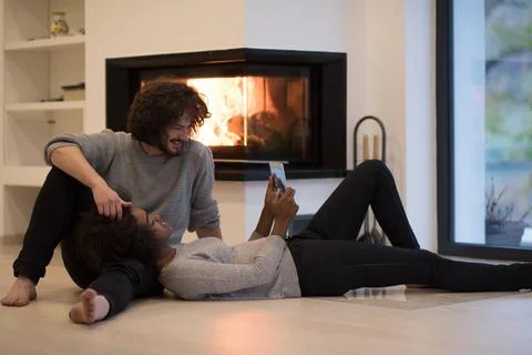 Multiethnic couple using tablet computer on the floor beautiful young mult... Stock Photos