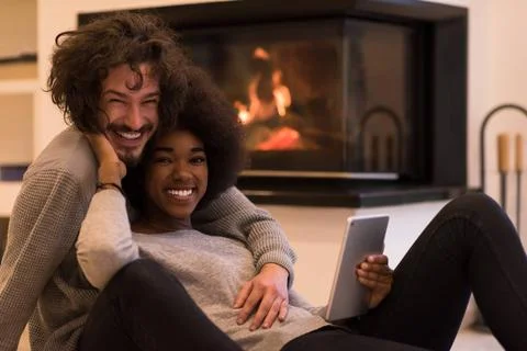 Multiethnic couple using tablet computer on the floor beautiful young mult... Stock Photos