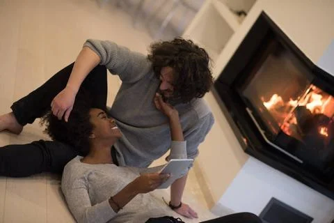 Multiethnic couple using tablet computer on the floor beautiful young mult... Stock Photos
