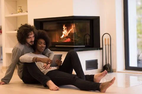 Multiethnic couple using tablet computer on the floor beautiful young mult... Stock Photos