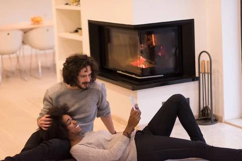 Multiethnic couple using tablet computer on the floor beautiful young mult... Stock Photos
