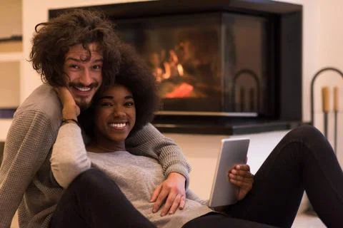 Multiethnic couple using tablet computer on the floor beautiful young mult... Stock Photos