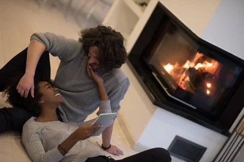 Multiethnic couple using tablet computer on the floor beautiful young mult... Stock Photos