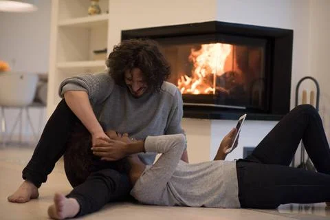 Multiethnic couple using tablet computer on the floor beautiful young mult... Stock Photos