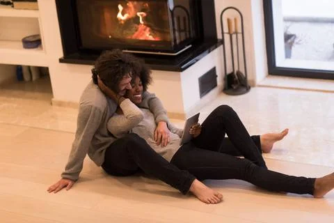 Multiethnic couple using tablet computer on the floor beautiful young mult... Stock Photos
