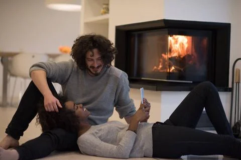 Multiethnic couple using tablet computer on the floor beautiful young mult... Stock Photos